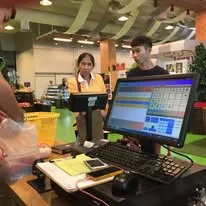 พนักงานหน้าร้านกำลังคิดเงินลูกค้าด้วยโปรแกรม Senfos บนจอสัมผัส